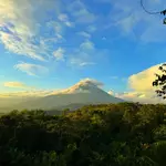 With a Self-Guide Tour of Costa Rica witness Arenal Volcano peering out of the mist in La Fortuna, Costa Rica