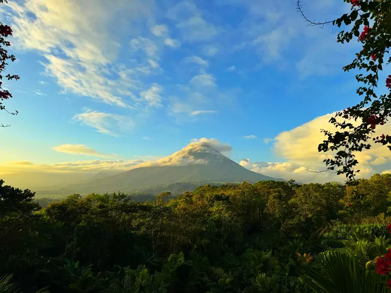 With a Self-Guide Tour of Costa Rica witness Arenal Volcano peering out of the mist in La Fortuna, Costa Rica