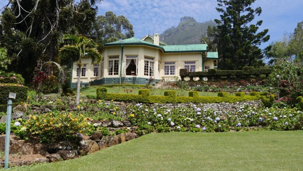 Sir Thomas Lipton's former bungalow on the Dambatenne estate, a colonial-era house with green trim set behind a manicured lawn.